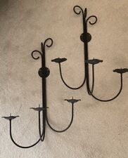 A Pair Of Black Wrought Iron Wall Mounted Candle Holders