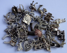 Vintage heavy solid silver charm bracelet &many curious silver charms inc moving
