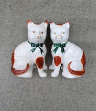 Pair of 8" vintage Staffordshire seated cat figurines with green bows.