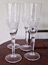 FOUR LARGE GLASS CHAMPAGNE FLUTES  .