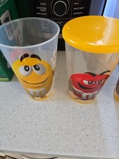 M&M World Cups with Yellow Lids. Plastic with Yellow and Red Ms Design