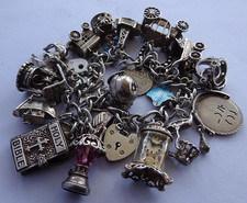 Vintage heavy solid silver charm bracelet &many curious silver charms inc moving