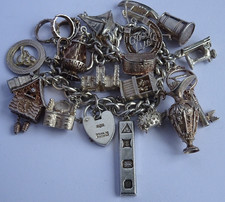 Vintage heavy solid silver charm bracelet &many curious silver charms inc moving