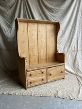 An antique early 19th century West Country pine and elm panel back settle