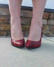 Worn red snakeskin heels, size