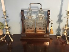 A FINE QUALITY ANTIQUE SOLID OAK TWO BOTTLE TANTALUS , WITH KEYS CIRCA 1920.