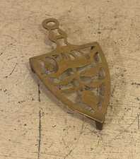 A vintage brass trivet stand with animal design