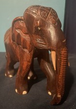 Vintage hand-carved wooden elephant with detailed etchings light-colored tusks.