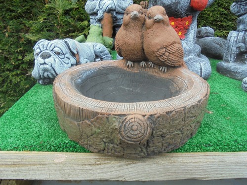 Birds cuddling bird bath
