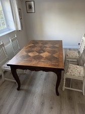 A French Provincial style dining table with parquetry top and cabriole legs