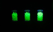 1 x DISPLAY BOTTLE OF URANIUM / VASELINE GLASS PIECES SHOWING UV FLUORESCENCE