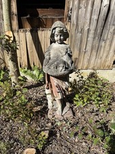 Large Vintage garden statue of a child holding a basket of puppies