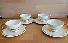 ROBJ ART DECO SET OF FOUR CREAM AND GILT STYLISED COFFEE CUPS AND SAUCERS