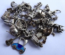 Vintage heavy solid silver charm bracelet &many curious silver charms inc moving
