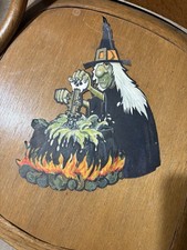 Halloween Witch  sitting next to a fire stirring The Caldron