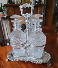 Georgian Silver plated footed stand with 3 cut glass decanters and stoppers.