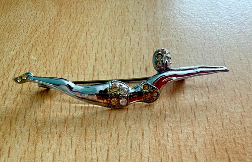 Silver coloured badge brooch