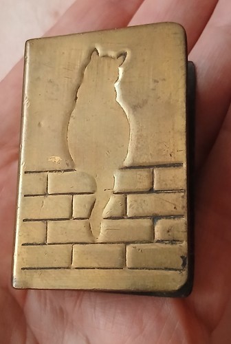Brass cat sitting wall - on,