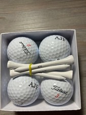 4 titleist golf balls and tees