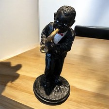 A figurine of a musician playing the saxophone, likely representing African Jazz