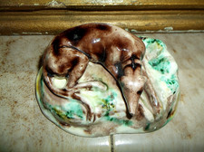 ANTIQUE 19TH C TREACLE GLAZED POTTERY RECUMBENT GREYHOUND ON NATURALISTIC BASE