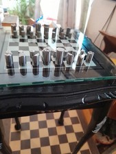 Minimalist Metal Pieces,On A Glass Chessboard,Placed Upon a Wooden Table-671BDRM