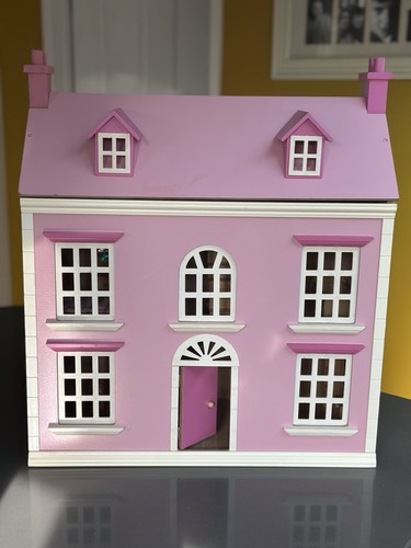 Pink wooden dolls house with