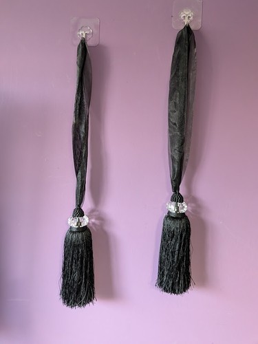 Four black curtain tie - -backs, &