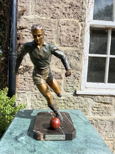 Bronze statue footballer - a, of