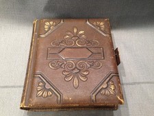 A antique Victorian photo album with some photos in it