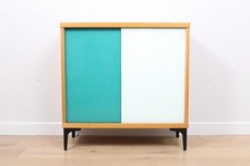 A vintage mid-century bookcase with teal and white sliding doors 2 of 2