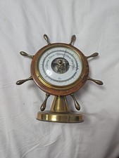 This is a vintage ship's wheel barometer