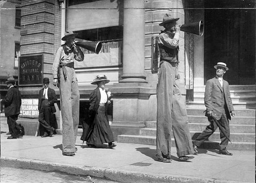 Men stilts announcing the - men,