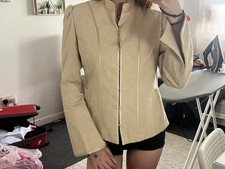 beige mandarin collar jacket with bell sleeves and hook-and-eye closures