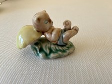 Vintage ceramic cat figurine lying against a mushroom