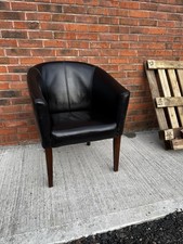 Black faux leather tub chair with dark brown wood legs