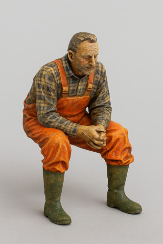 Seated fisherman figure