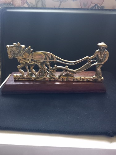 Brass farmer ploughing with - a,