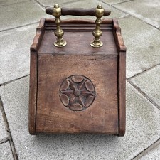 Antique Art Nouveau wooden coal scuttle with brass handles and carved motif.